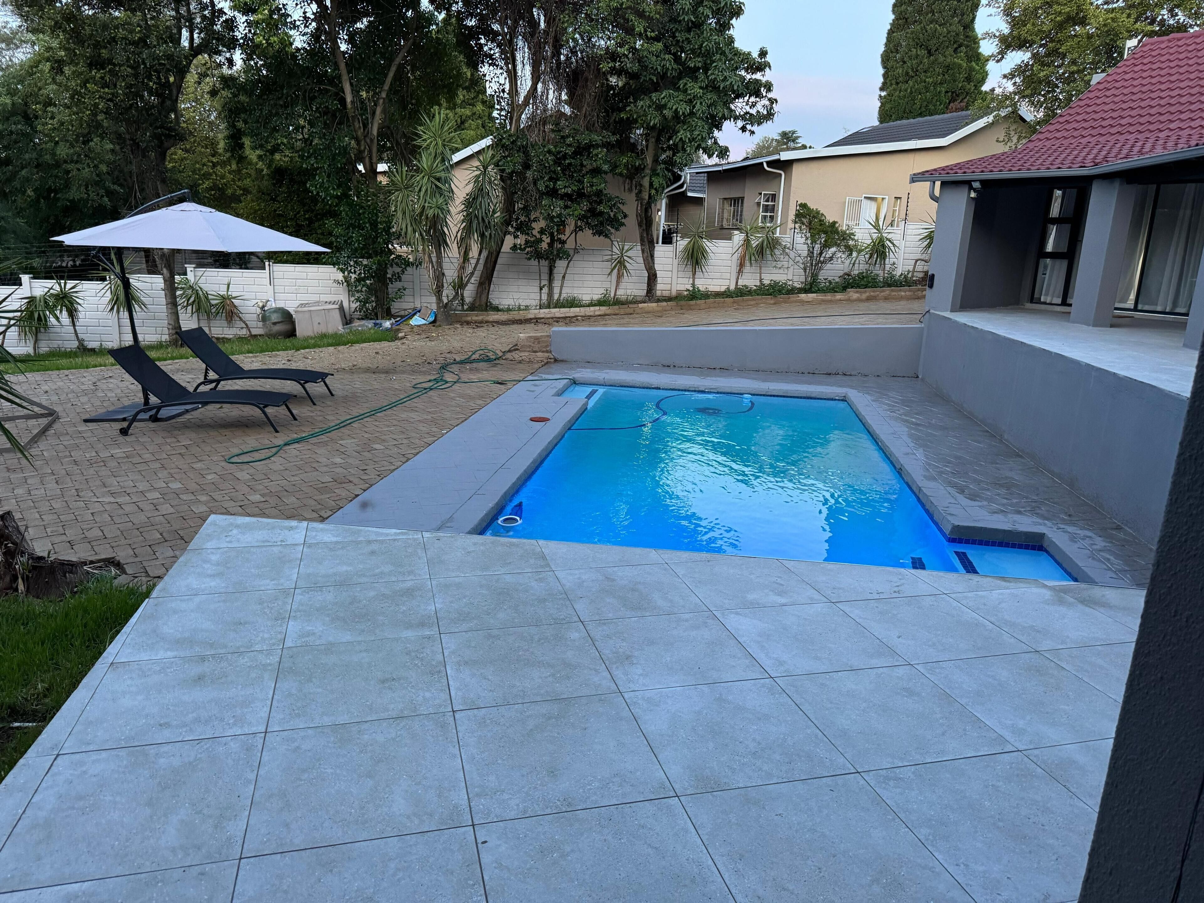 室外游泳池，池畔遮阳伞，日光浴躺椅