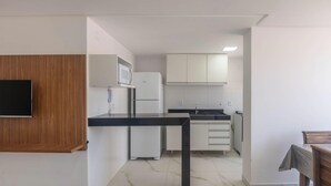 A modern kitchen with white cabinets, a black countertop, and a built-in microwave. - Apartments Just 270 Meters From Praia do Morro, Guarapari - Epus (Guarapari)