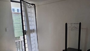A room with two beds, a small table, a chair, and a clothes rack. - Hotel Morelia Nova (Morelia)
