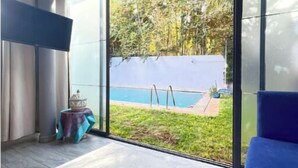 A modern bedroom with a large sliding glass door leading to a pool area. - A haven of peace in Dar Bouazza (Casablanca)