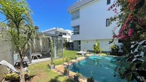 A modern building with a swimming pool, surrounded by greenery and a clear blue sky. - A haven of peace in Dar Bouazza (Casablanca)