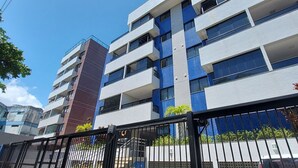 Un immeuble à plusieurs étages doté d’une architecture moderne, avec des balcons et de grandes fenêtres.