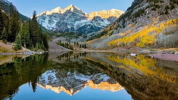 A mountain lake with reflections of the mountains and trees.
