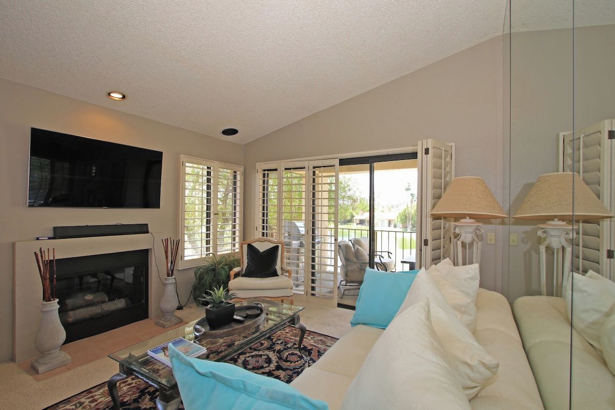 Settle into your inviting living space with cozy seating, a warm fireplace, and direct access to your private patio where relaxation awaits.