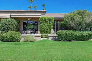 Your private retreat showcases lush landscaping and a peaceful patio with ceiling fan, perfect for relaxing under blue desert skies and towering palms. - Spacious-Dogs Ok-Great Views-VB887 (Palm Desert)