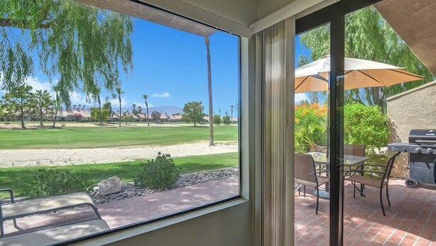 A patio with a view of a golf course, outdoor furniture, and a grill. - Great Golf Condo with Access to Resort Amenities (Palm Desert)