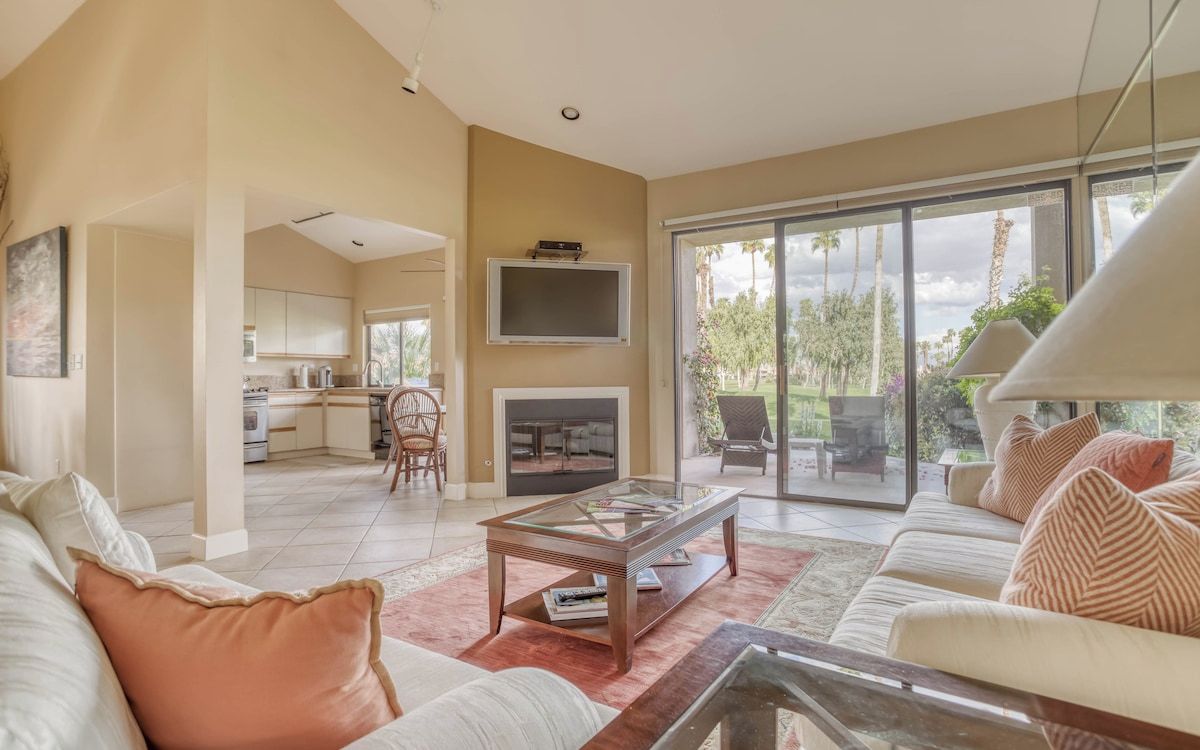 Relax in your sun-drenched living room, where floor-to-ceiling glass doors open to your private patio and garden views. A cozy fireplace and plush seating invite you to unwind after exploring nearby attractions.