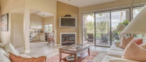 Settle into your bright, open living room where plush sofas invite relaxation and sliding doors open to a peaceful garden view and your private patio.