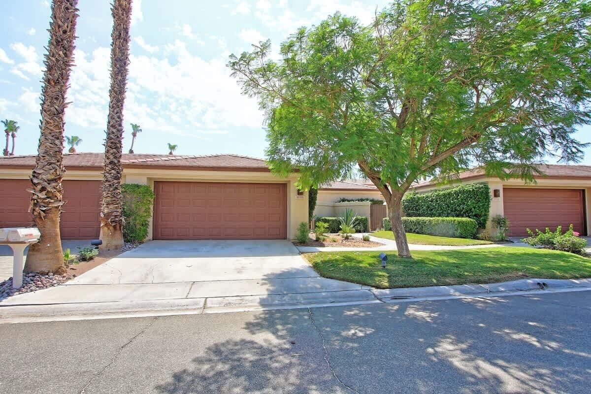 A residential house with a garage, a driveway, and a well-maintained lawn.