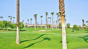 A golf course with palm trees and a building in the background. - Moutain and Fairway Views-Walk to Pool-V3986 (Palm Desert)