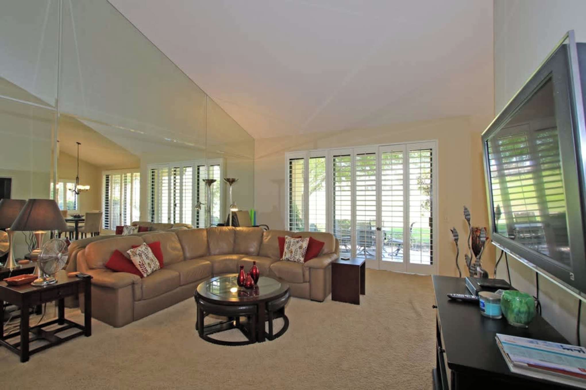 Sink into the plush sectional and let natural light stream through plantation shutters opening to your private patio—your perfect retreat for unwinding after a day of exploring.