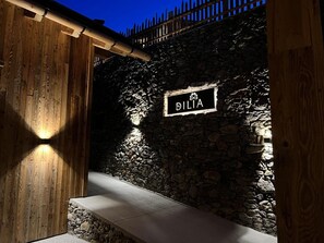 A stone wall with a sign reading 'DILIA' and a wooden structure to the left. - Apartment Relax with Mountain View, Sauna and Wi-Fi (Mühlbach)