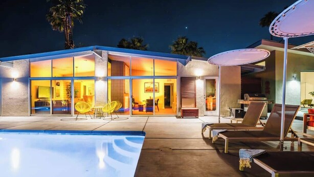 Une maison moderne dotée d’une piscine, d’un espace extérieur aménagé et d’une entrée bien éclairée.