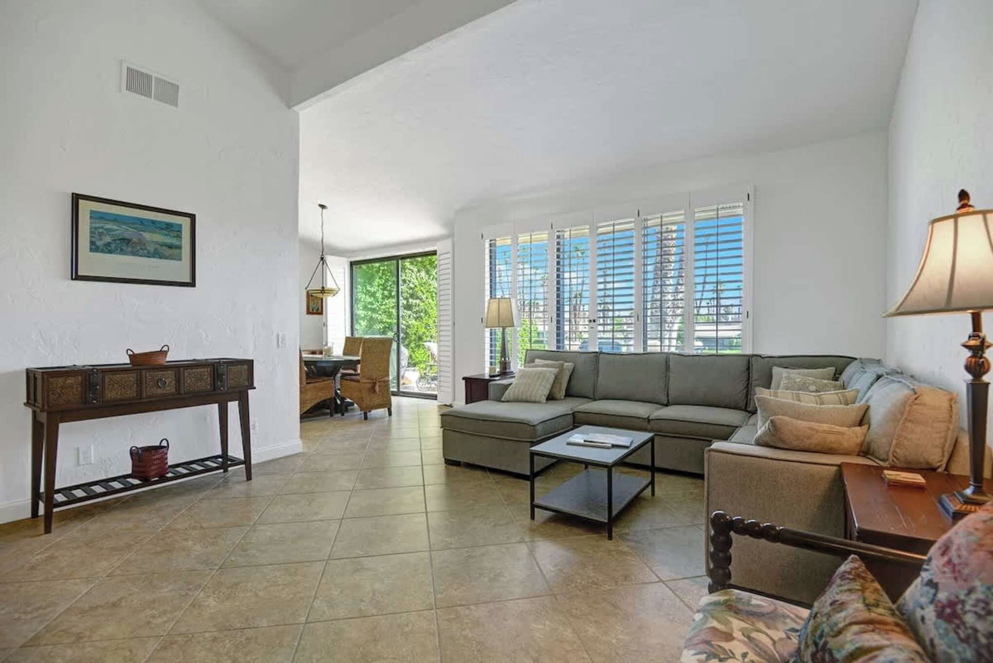 Settle into this bright living room where natural light streams through large windows and sliding doors. Sink into the plush sectional with your favorite book, or gather around the coffee table for board games and conversation.