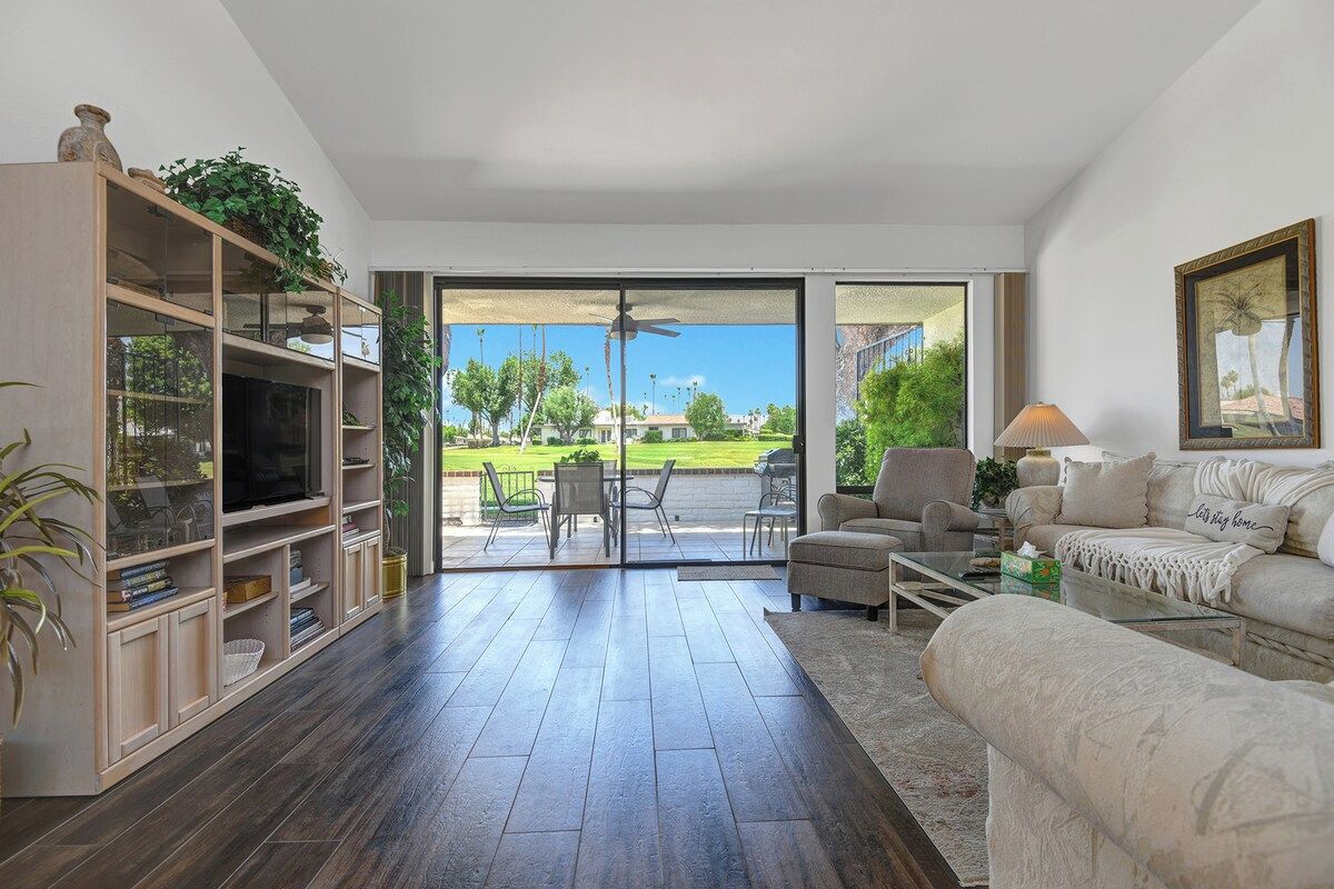 Step into a welcoming living space where natural light floods through expansive glass doors opening to your private patio and lush green surroundings. Unwind on plush seating and soak in the serene golf course views.