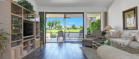 Step into a welcoming living space where natural light floods through expansive glass doors opening to your private patio and lush green surroundings. Unwind on plush seating and soak in the serene golf course views.