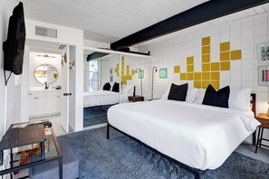 Unwind in your stylish bedroom featuring crisp white linens, bold graphic wall art, and a clever mirrored accent that makes your space feel even more open and airy. - Retro Mid-Century Modern Retreat at Historic Ocotillo Lodge (Palm Springs)