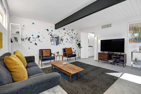 Step into your bright, stylish living room where mid-century modern charm meets playful artistic flair. Sink into plush seating, gather around the handcrafted coffee table, and unwind in a space designed for relaxation. - Retro Mid-Century Modern Retreat at Historic Ocotillo Lodge (Palm Springs)