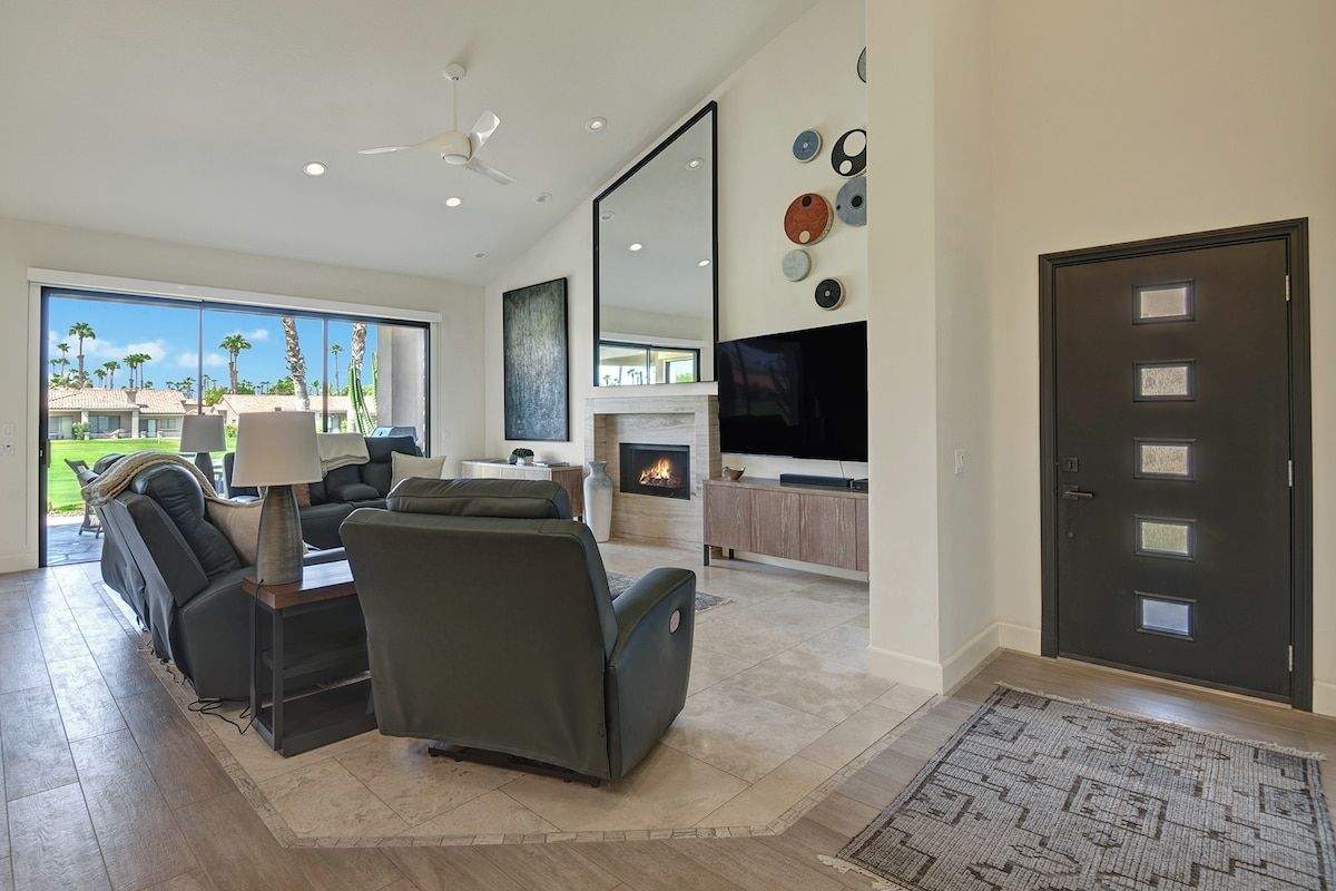 Step into your own desert oasis where modern elegance meets warm comfort. Relax in the spacious living room framed by soaring ceilings, a glowing fireplace, and sweeping views of palm-lined fairways just beyond your glass doors.