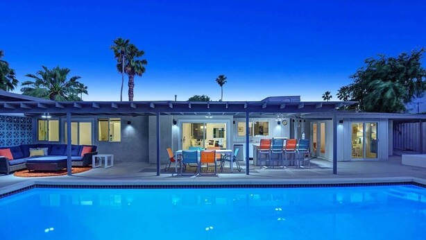 A modern outdoor pool area with a dining setup and seating. - Teal and Tangerine Retreat - Movie Colony East - 5 mins to downtown, perfect 3 bedroom, 3 bath, Pool, Spa & Casita (Palm Springs)
