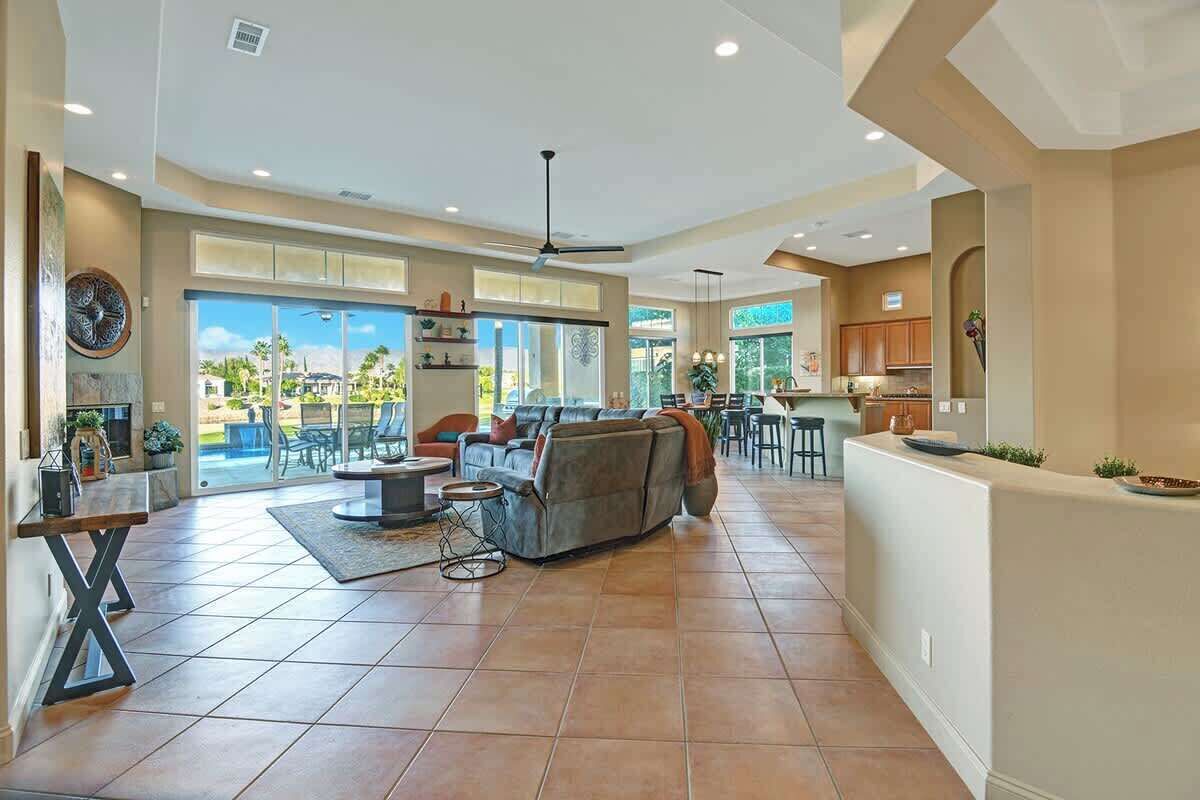 A spacious living area with a large sofa, a dining table, and a kitchen area with cabinets and a countertop.