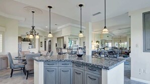A spacious kitchen with granite countertops, grey cabinetry, and pendant lighting. - Spacious Condo|Great Views|Platinum Membership (Palm Desert)