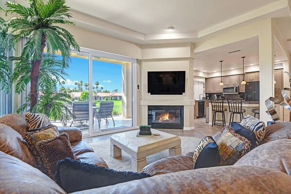 A spacious living room with a fireplace, a large TV, and a comfortable seating area. - Spacious Condo|Great Views|Platinum Membership (Palm Desert)
