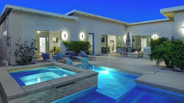 A modern house with a swimming pool and outdoor seating area. - Pet-friendly Desert Park home with heated pool|Spa (Palm Springs)