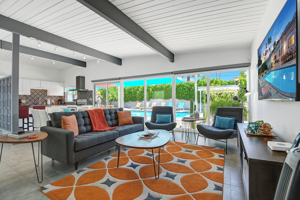 Sink into the plush sofa and soak in the seamless indoor-outdoor vibe—vaulted ceilings, sleek modern accents, and your private pool just steps away through floor-to-ceiling windows.