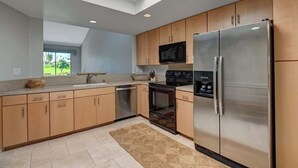 A modern kitchen with wooden cabinets, stainless steel appliances, and a skylight. - Fairway View Escape in Palm Desert (Palm Desert)