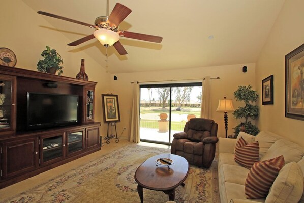 Relax in your spacious living room with comfortable seating and peaceful views of the lush golf course just beyond your patio doors. - Two Bedroom Holiday Home (Palm Desert)