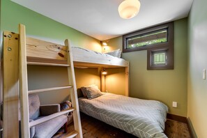A bunk bed room with a ladder, a single bed, a small window, and a wall-mounted light fixture. - Hazel Studio - King Bed Studio with Twin Bunkbeds in side room. Full kitchen, bathroom and covered front porch. (Franklin)