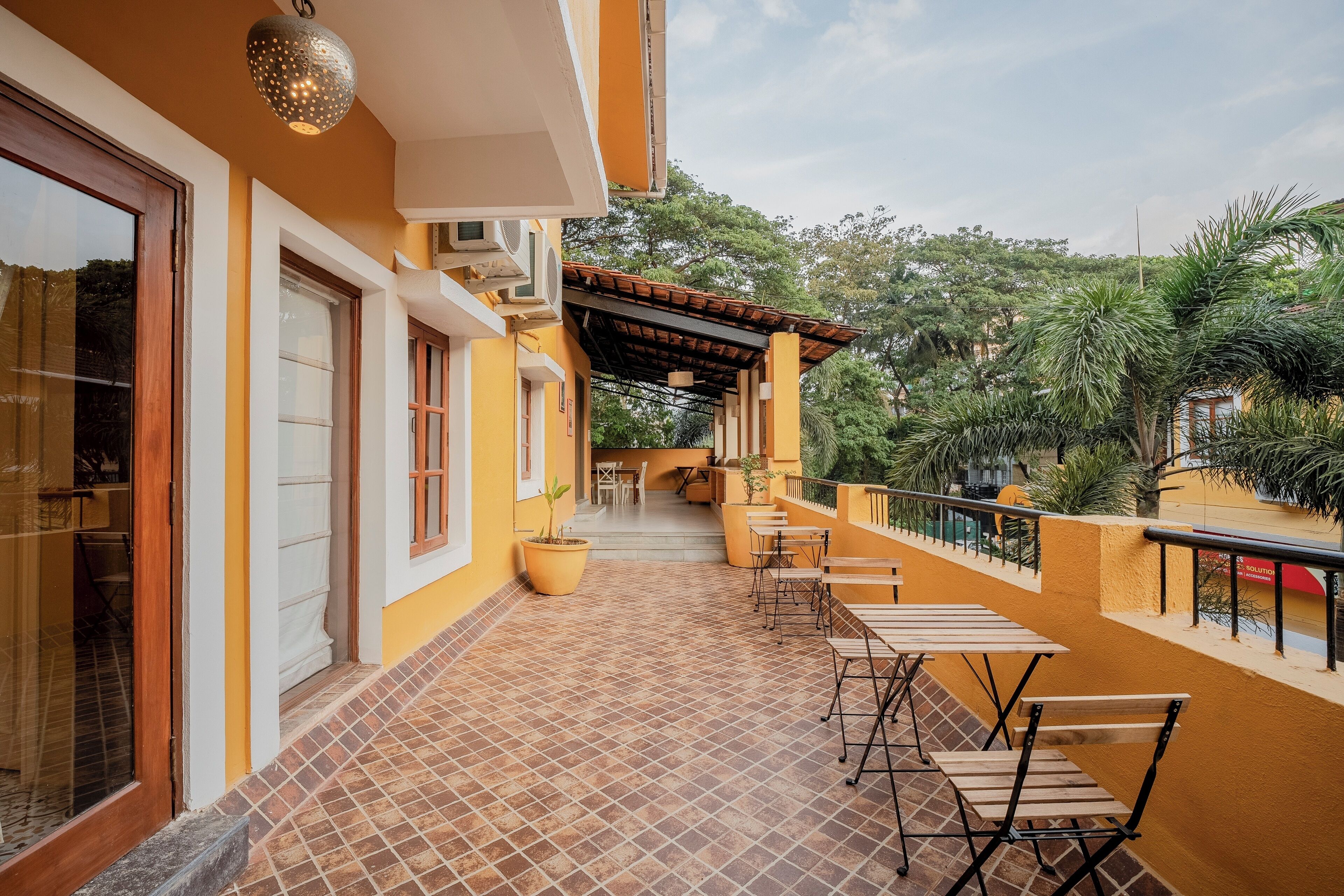 A covered outdoor area with tiled flooring, a pergola, and outdoor seating.