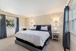 A bedroom with a large bed, two bedside tables, and two wall-mounted lamps. - Mid-Century Modern House, Boise Central Rim, Walk/Bike Downtown & Parks (Boise)
