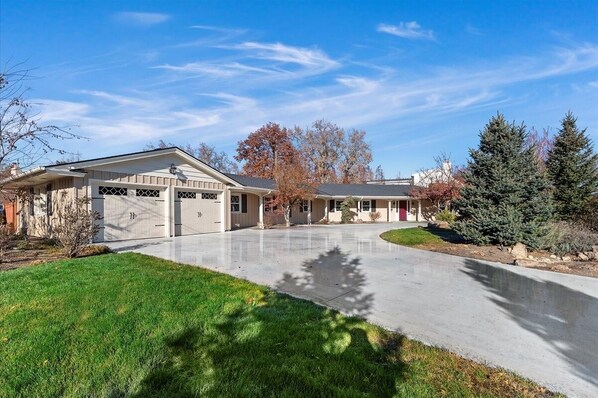 A two-story house with a garage, a driveway, and a well-maintained lawn. - Mid-Century Modern House, Boise Central Rim, Walk/Bike Downtown & Parks (Boise)