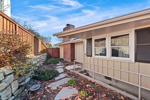 A residential property with a stone retaining wall, a brick chimney, and a pathway leading to the entrance. - Mid-Century Modern House, Boise Central Rim, Walk/Bike Downtown & Parks (Boise)