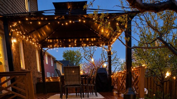 A wooden deck with steps leading to a covered patio area, outdoor furniture, and string lights. - Walk to Convention Centre, Restaurants, Falls! 3BR (Niagara Falls)