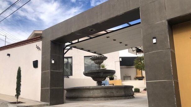 A modern building entrance with a concrete structure, a small tree, and a fountain. - Charming 1 BR home w/private yard-walk to downtown (Durango)