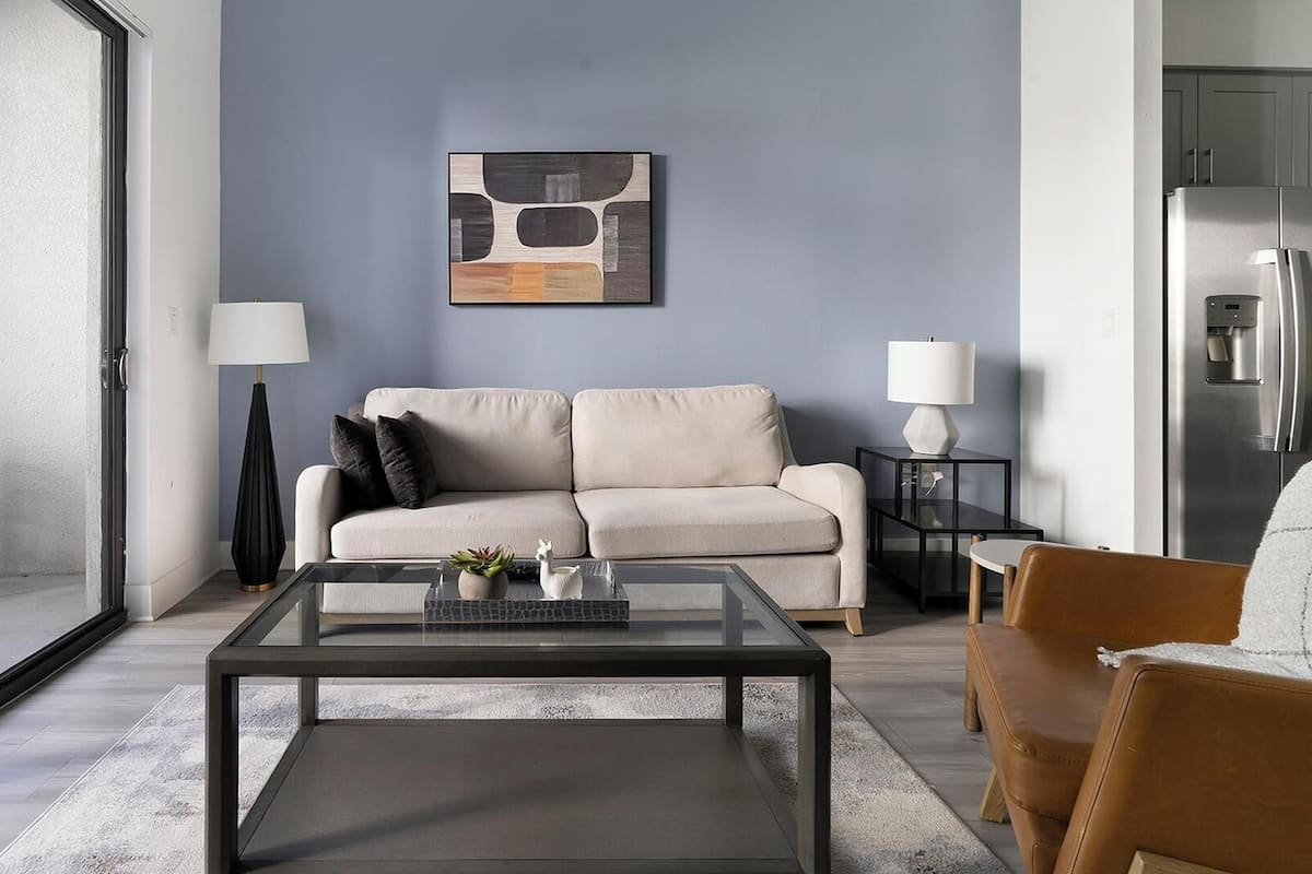 A modern living room with a sofa, coffee table, and two lamps.