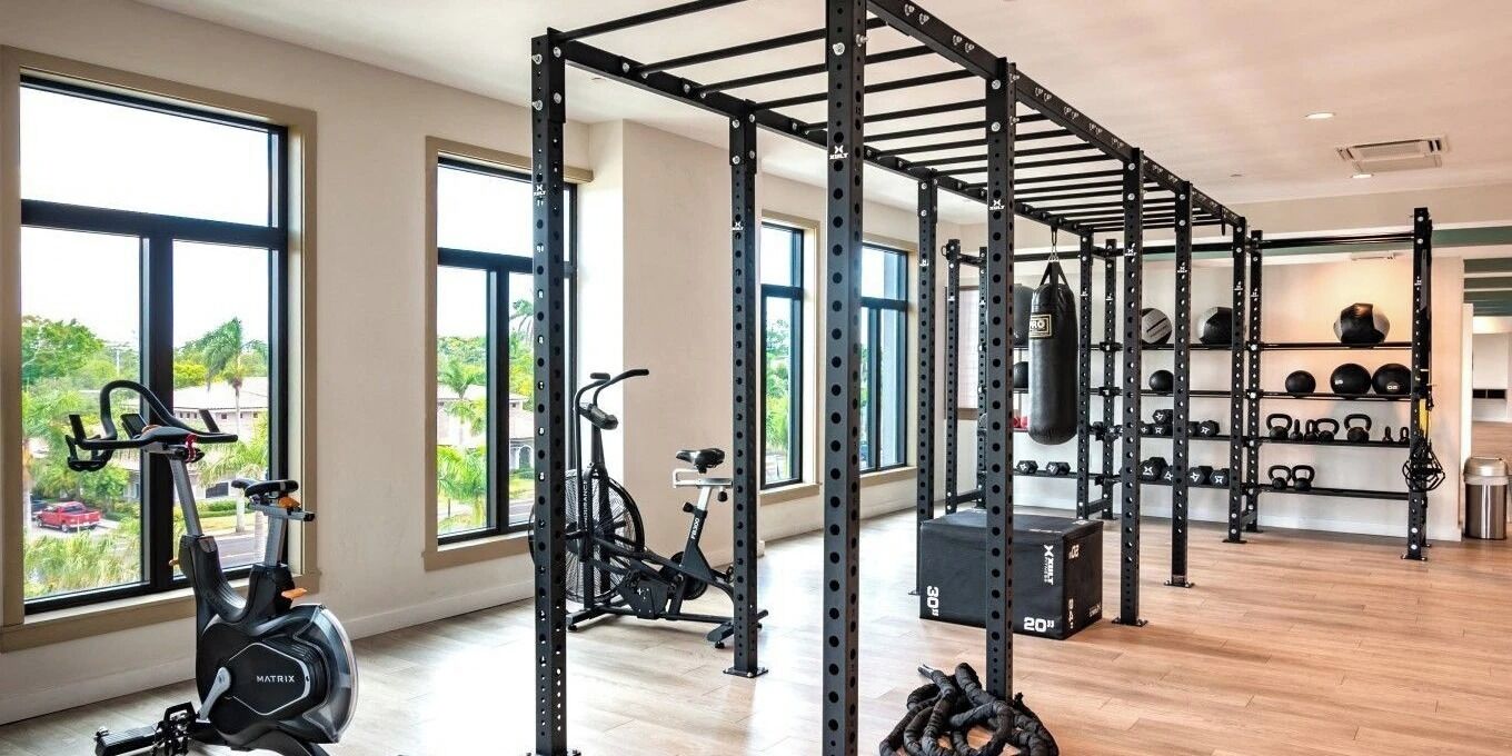 A spacious gym with a pull-up bar, exercise bike, and weightlifting equipment.