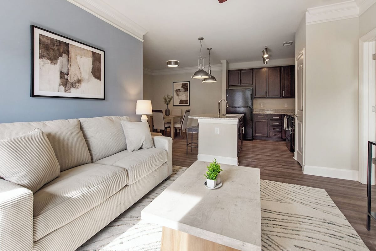 A modern living room with a sofa, coffee table, and artwork on the wall.