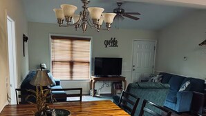A dining area with a wooden table, chairs, a chandelier, and a ceiling fan. - Charming 2-bedroom lakehouse with HVAC in cozy Roxboro (Roxboro)