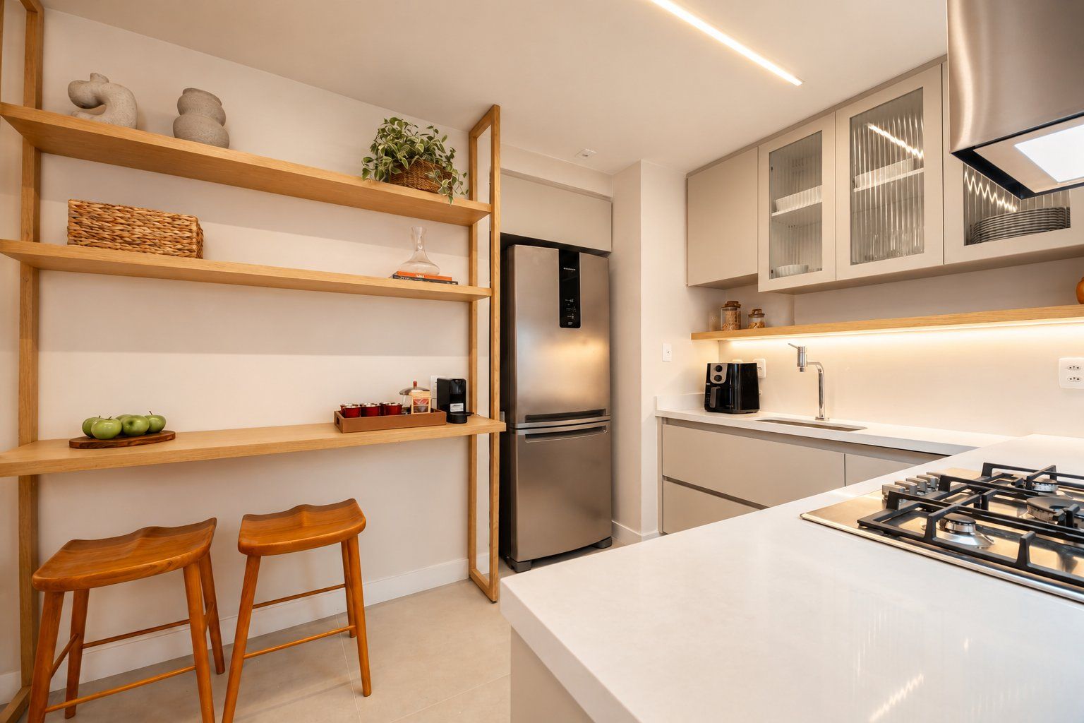 A modern kitchen with wooden shelves, a built-in refrigerator, a gas stove, and two wooden stools.