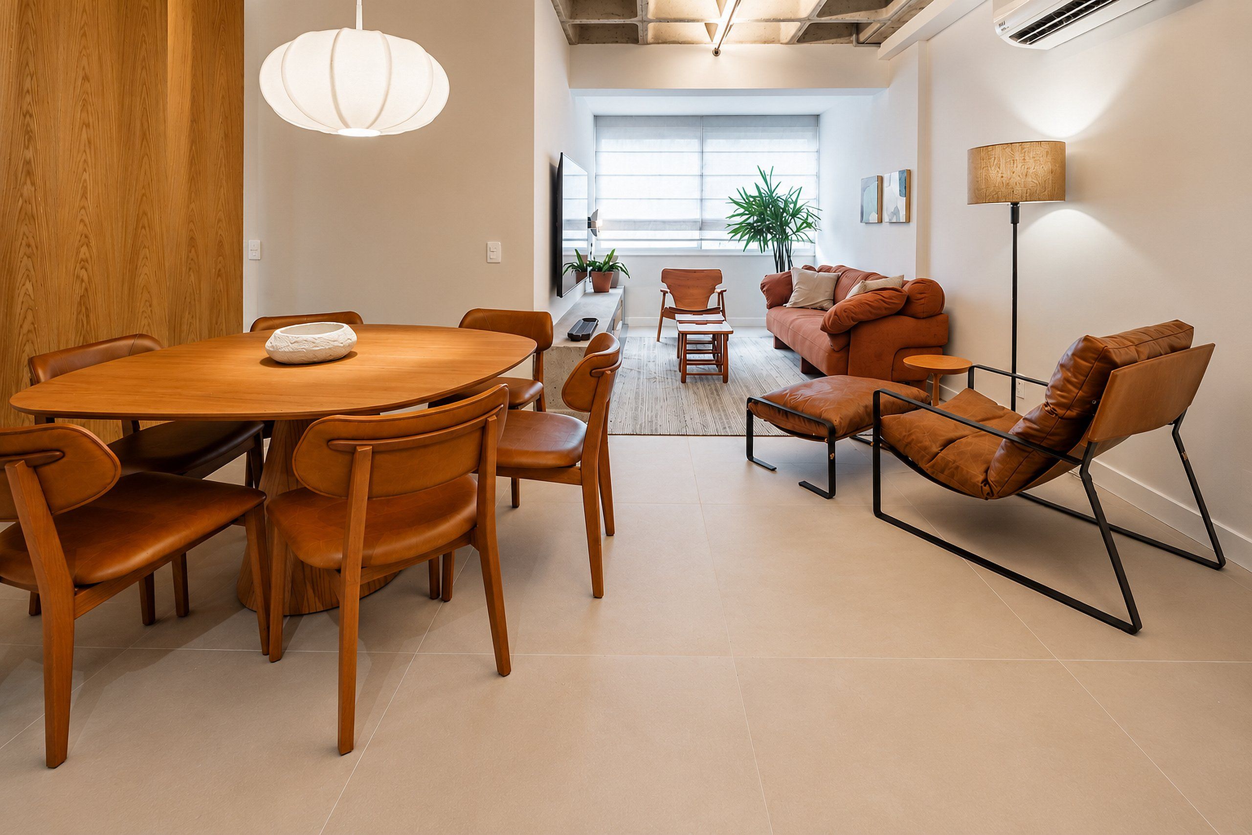 A modern interior with a dining area, a sofa set, and a floor lamp.