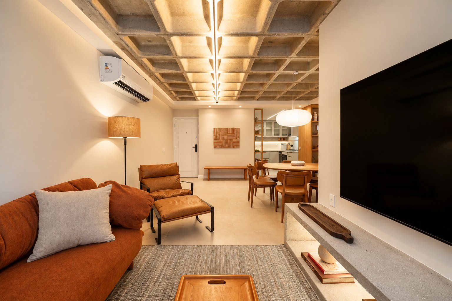 A modern living room with a sofa, armchair, and dining area.