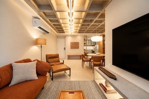 A modern living room with a sofa, armchair, and dining area. - Leblon | 3 Quartos, 2 min da Praia - por Casapē Rio (Rio de Janeiro)