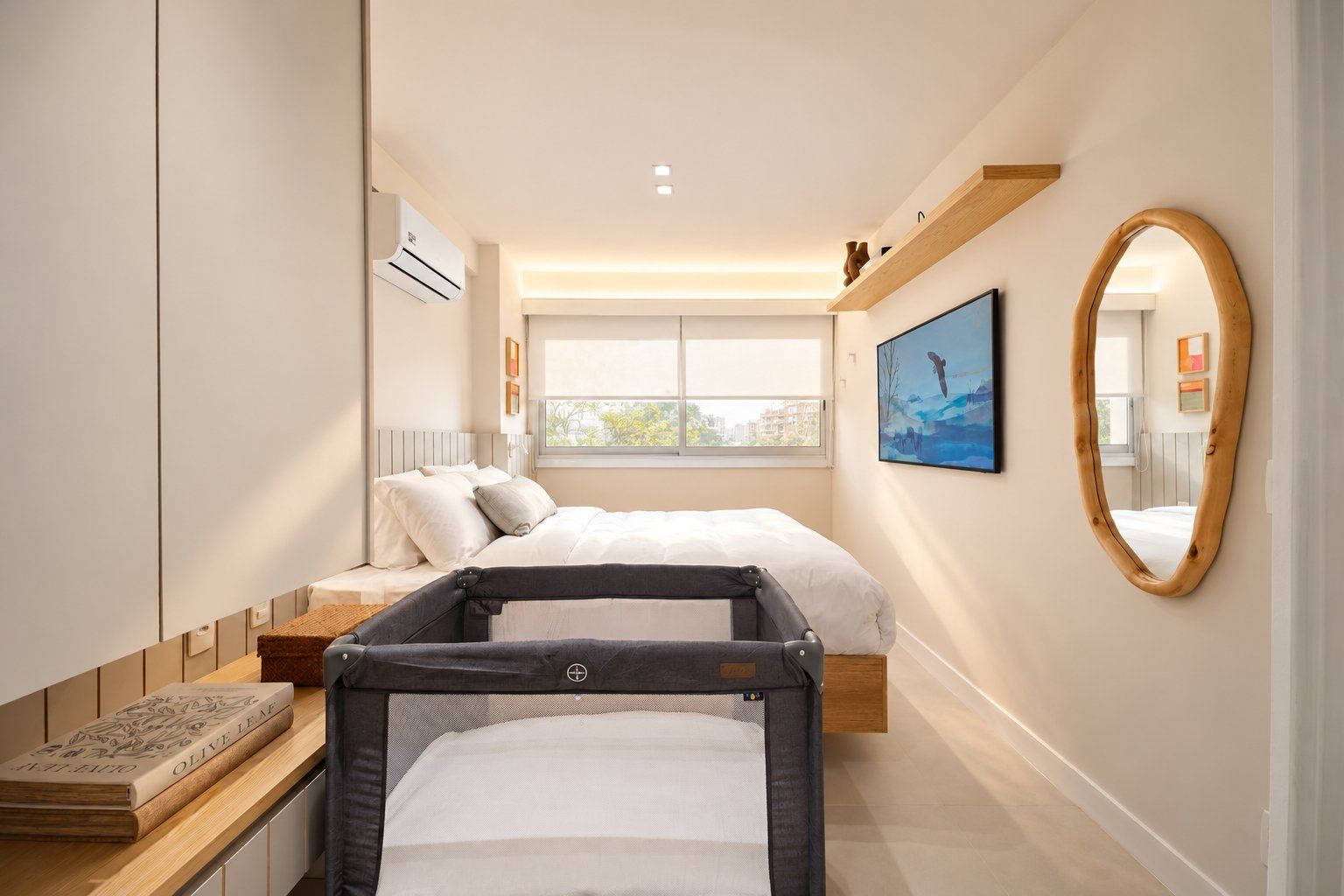 A modern bedroom with a bed, bedside table, and a crib.