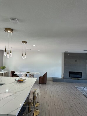 A modern kitchen with a marble countertop, pendant lights, and a dining area with a marble table. - Newly remodeled, spacious 4-bedroom house in serene Phoenix (Phoenix)