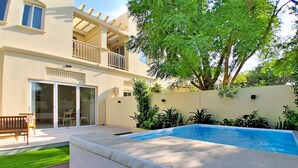 Il s’agit d’une propriété résidentielle dotée d’une piscine, d’un patio couvert et d’un bâtiment à deux étages avec des balcons.