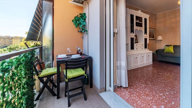 Ein Balkon mit Tisch, Stühlen und einem Blumentopf.